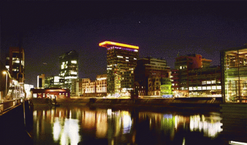 City At Night With River And Yellow Light On Building GIF