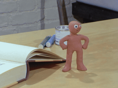 Clay Figure Standing Next To Book GIF