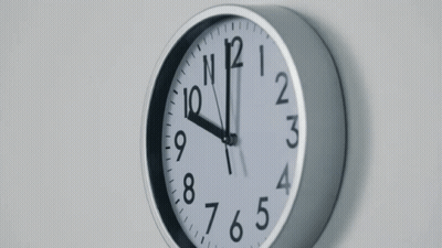 Clock On White Wall Showing Almost Eleven GIF
