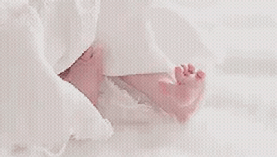 Close Up Baby's Feet On White Blanket GIF