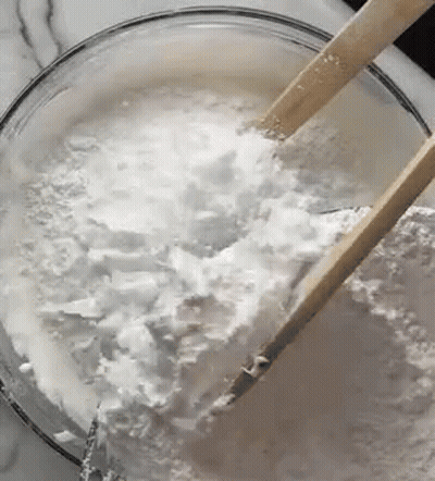 Close Up Bowl Of Powdered Sugar With Wooden Spoons GIF