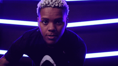 Close Up Face With Purple Lights Behind GIF