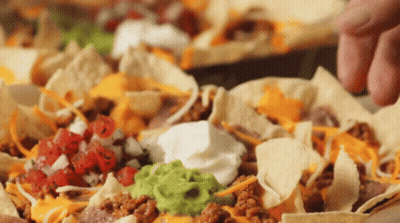 Close Up Nachos With Guacamole, Sour Cream, And Cheese GIF