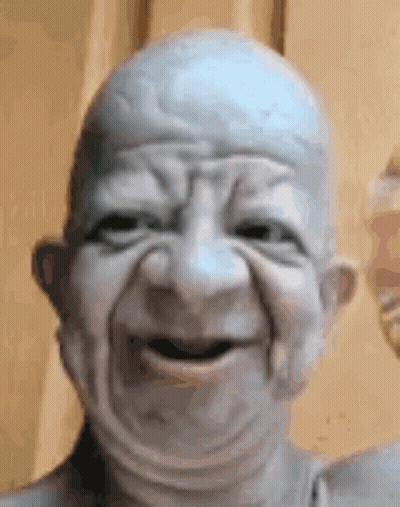 Close Up Of Bald Old Man Statue Making Face GIF