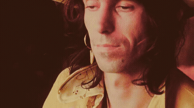 Close Up of Man in Hat and Earrings Looking at Camera