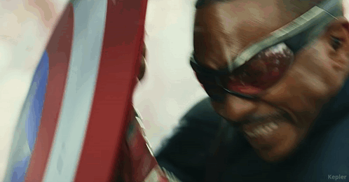 Close Up Of Man In Sunglasses Holding Shield GIF