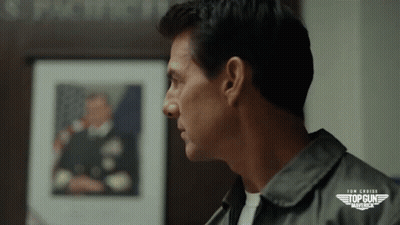 Close Up Of Man's Face In Front Of Top Gun Maverick GIF