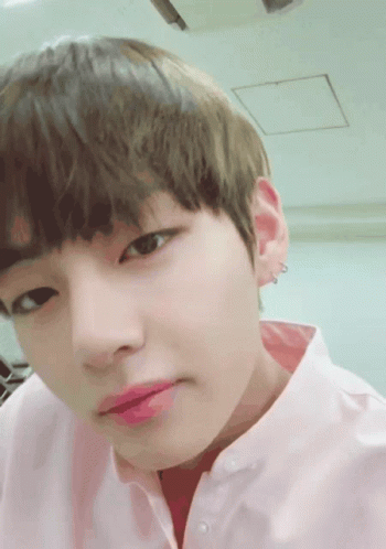 Close Up Of Person In Pink Shirt And Earrings GIF