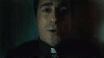 Close Up Of Priest's Face With Cross GIF