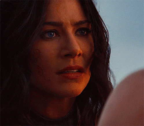 Close Up Of Woman's Face With Dark Hair And Blue Eyes GIF