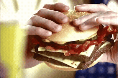 Close Up Person Holding Hamburger With Cheese And Bacon GIF