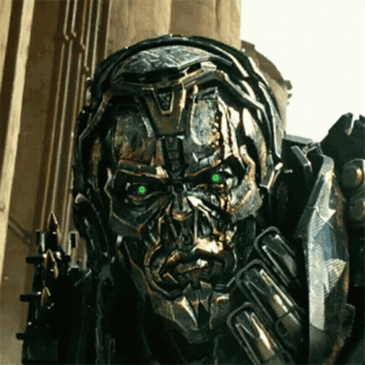 Close Up Robot With Green Eyes In Front Of Building GIF