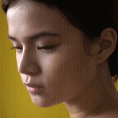 Close Up Woman's Face Against Yellow GIF