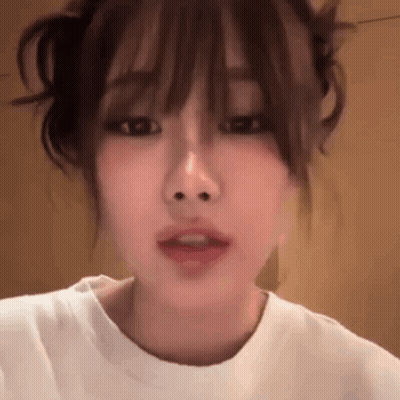 Close Up Woman's Face With White Shirt And Bun GIF