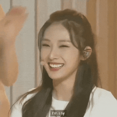 Close Up Woman Smiling Saying I'm Shy GIF