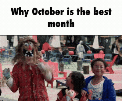 Clown Standing In Front Of Group Holding Doll GIF