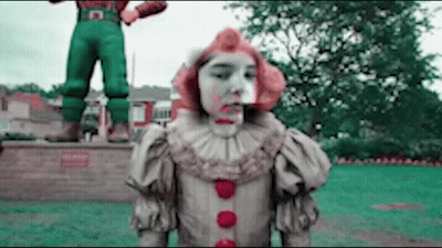 Clown With Blood On Face In Front Of Man Statue GIF