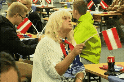 Coca Cola Bottle Next To Woman Holding Flag GIF