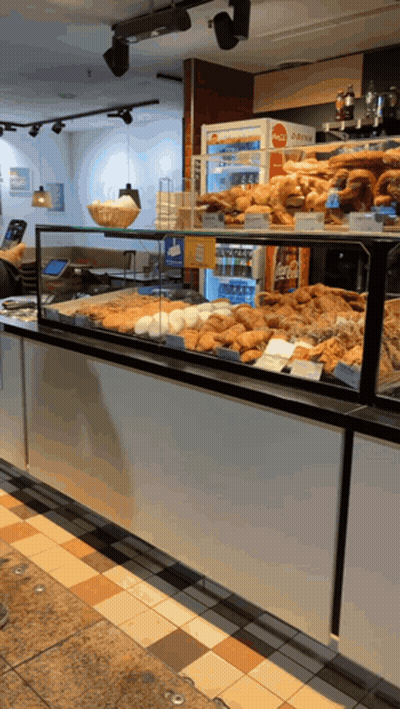 Refrigerador de Coca Cola detrás de una vitrina de pasteles GIF