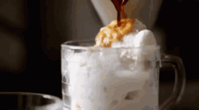 Coffee Is Being Poured Into A Glass Of Ice Cream And Whipped Cream . GIF