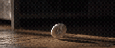 Coin Falling On Wooden Floor In Dark Room GIF