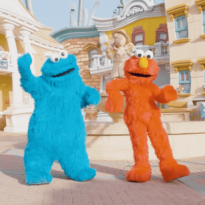 Cookie Monster And Elmo From Sesame Street Are Dancing In Front Of A Building GIF