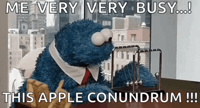 Cookie Monster From Sesame Street Is Sitting At A Desk With A Newton 'S Cradle In Front Of Him . GIF