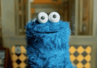 Cookie Monster From Sesame Street Is Smiling And Looking At The Camera With Big White Eyes . GIF