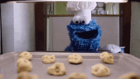Cookie Monster Wearing A Chef 'S Hat Is Looking At Cookies On A Pan GIF