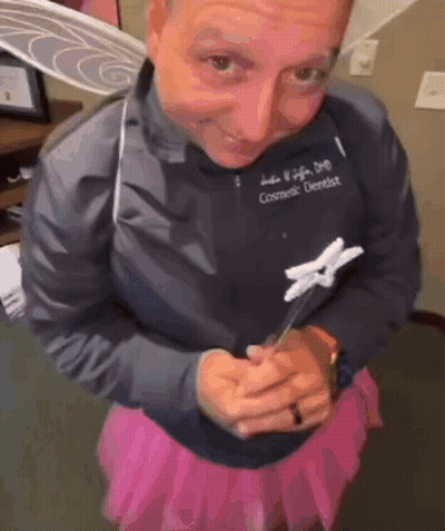 Cosmetic Dentist In Pink Skirt Holding Toothbrush GIF