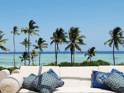 Couch With Blue Pillows On Balcony Overlooking Ocean GIF