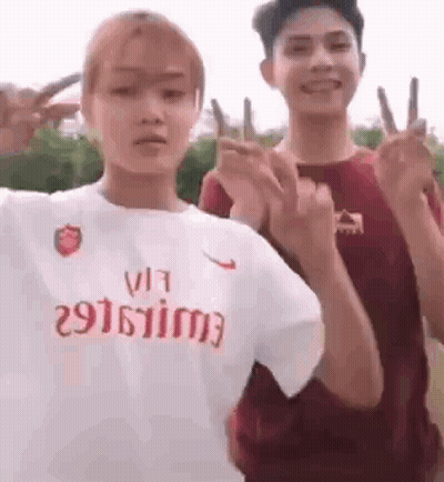 Couple Giving Peace Signs, Woman In Nike Shirt GIF