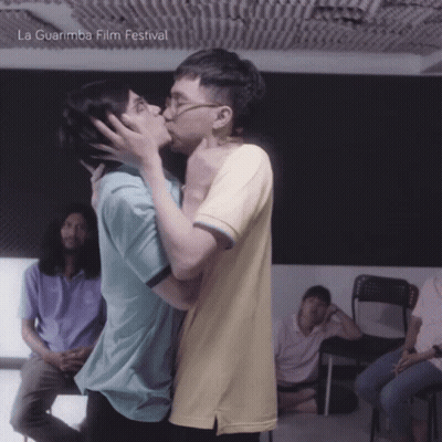 Couple Kissing In Front Of La Guarimba Film Festival Poster GIF