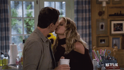 Couple Kissing In Front Of Netflix Box GIF