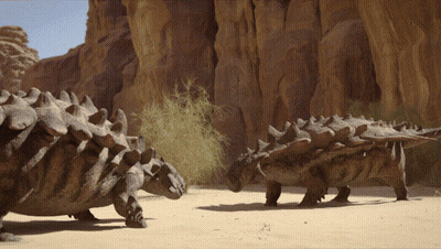 Couple Of Dinosaurs Standing Near Rock Formation GIF