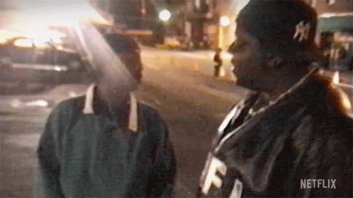 Couple Of Men Standing Next To Each Other On Street GIF