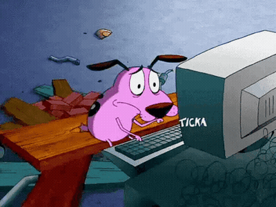 Courage The Cowardly Dog Is Sitting At A Desk Looking At A Computer Screen GIF