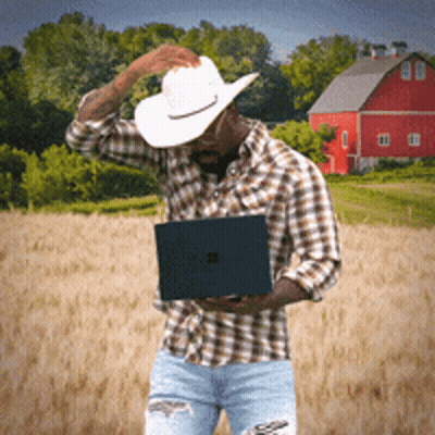Cowboy Hat Man Holding Laptop In Front Of Red Barn GIF