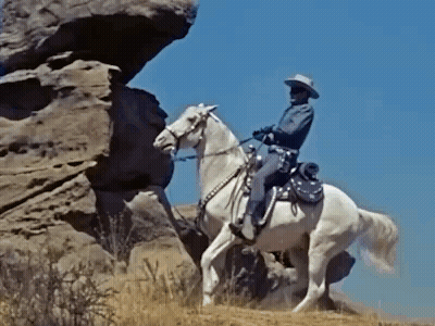 Cowboy Riding White Horse On Rock GIF