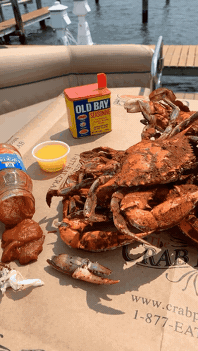 Crabs And A Can Of Old Bay Seasoning On A Table GIF