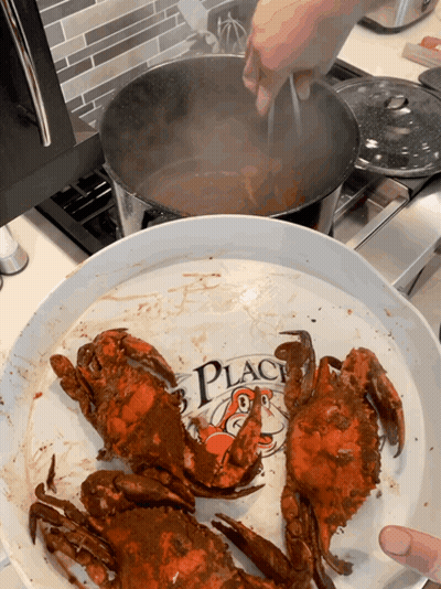 Crabs Are Being Cooked On A Plate That Says " Crab Place " GIF