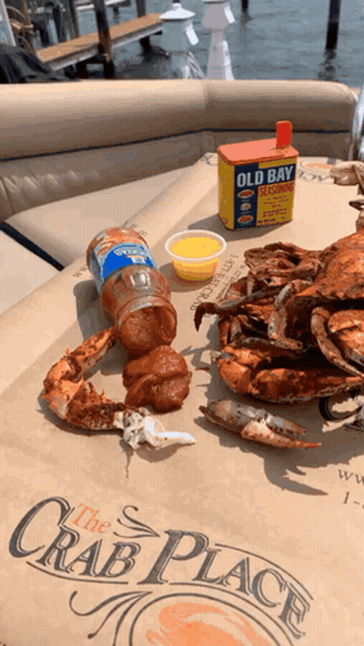 Crabs Are Sitting On A Table With A Box Of Old Bay Seasoning In The Background GIF