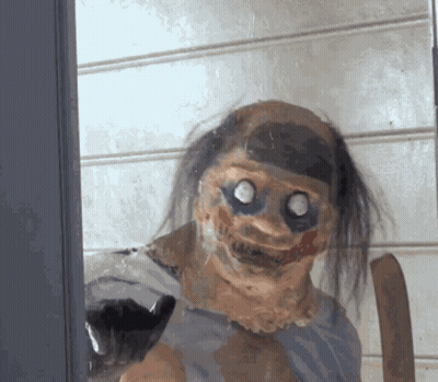 Creepy Clown Behind Glass Door Looking At Camera GIF