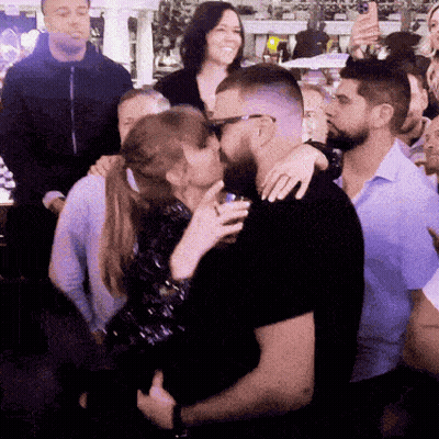 Crowd Around Kissing Man And Woman GIF