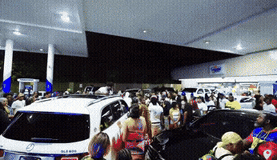 Crowd At Gas Station With White Mercedes GIF