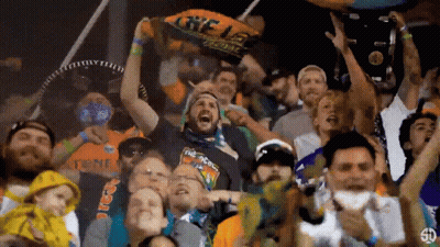 Crowd at Stadium With Man in The Goons Shirt