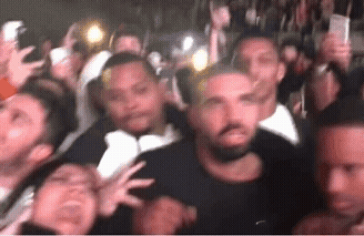 Crowd Gathered Around Man In Black Shirt GIF