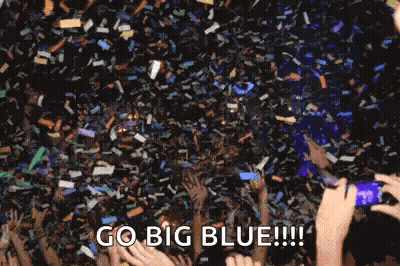 Crowd Holding Hands Up With Confetti GIF