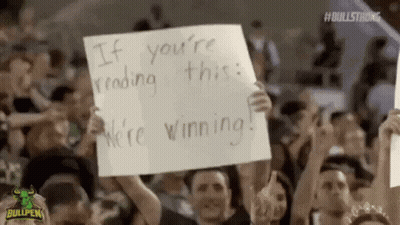 Crowd Holding Signs Saying If You're Reading This We're Winning GIF