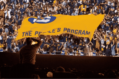 Crowd Holding Yellow Banner Saying The Peace Program GIF